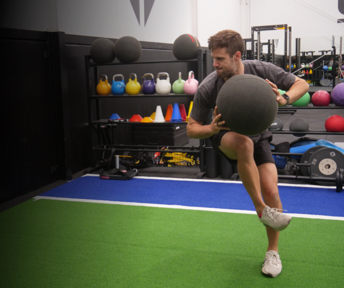 An athlete training with velocity based training on a wall ball exercise